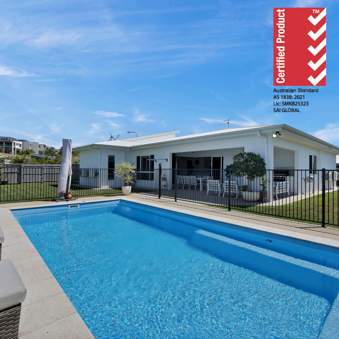 Swimming pool in front of a house with a blue sky and a certified product badge on the right.