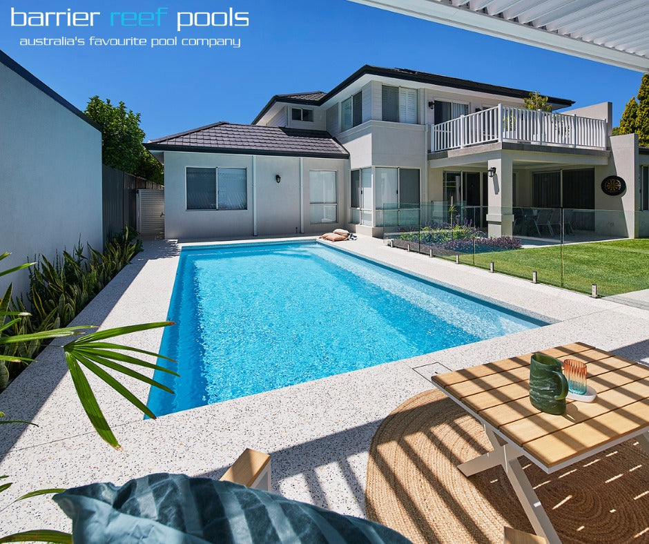 Modern house with a pool in a residential area, featuring Barrier Reef Pools branding.