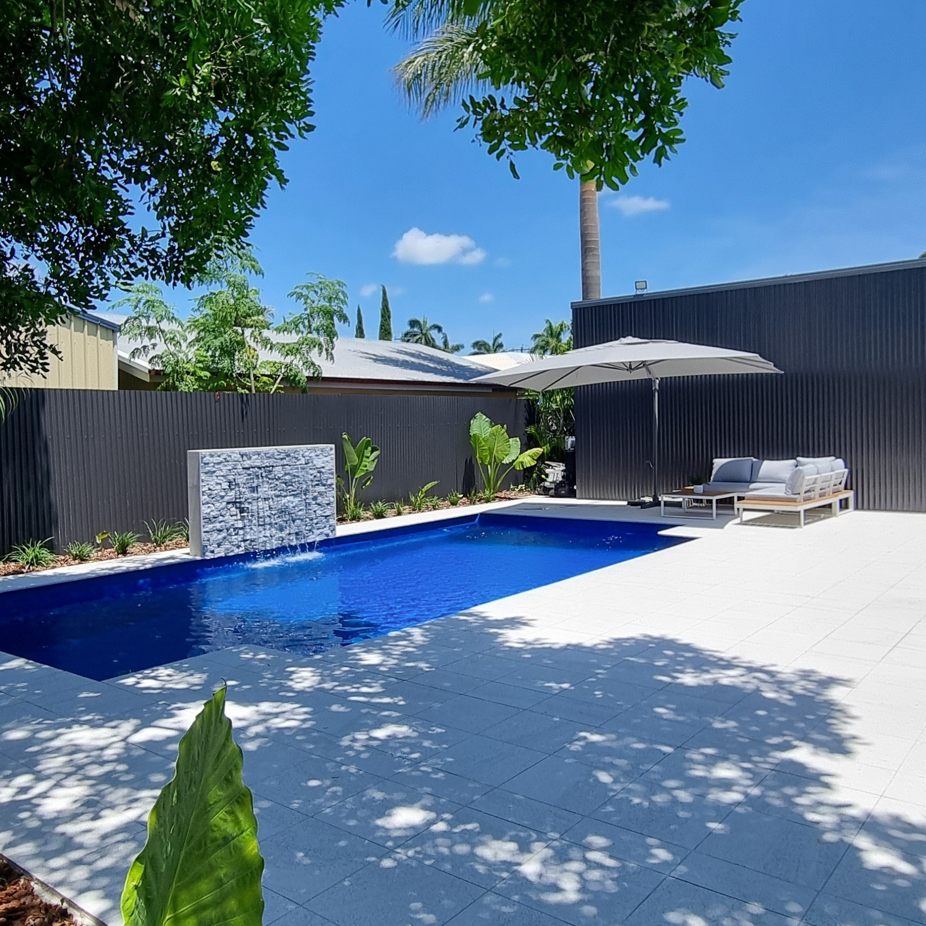 Venice pool installed with surrounds fully tiled and seating and umbrella