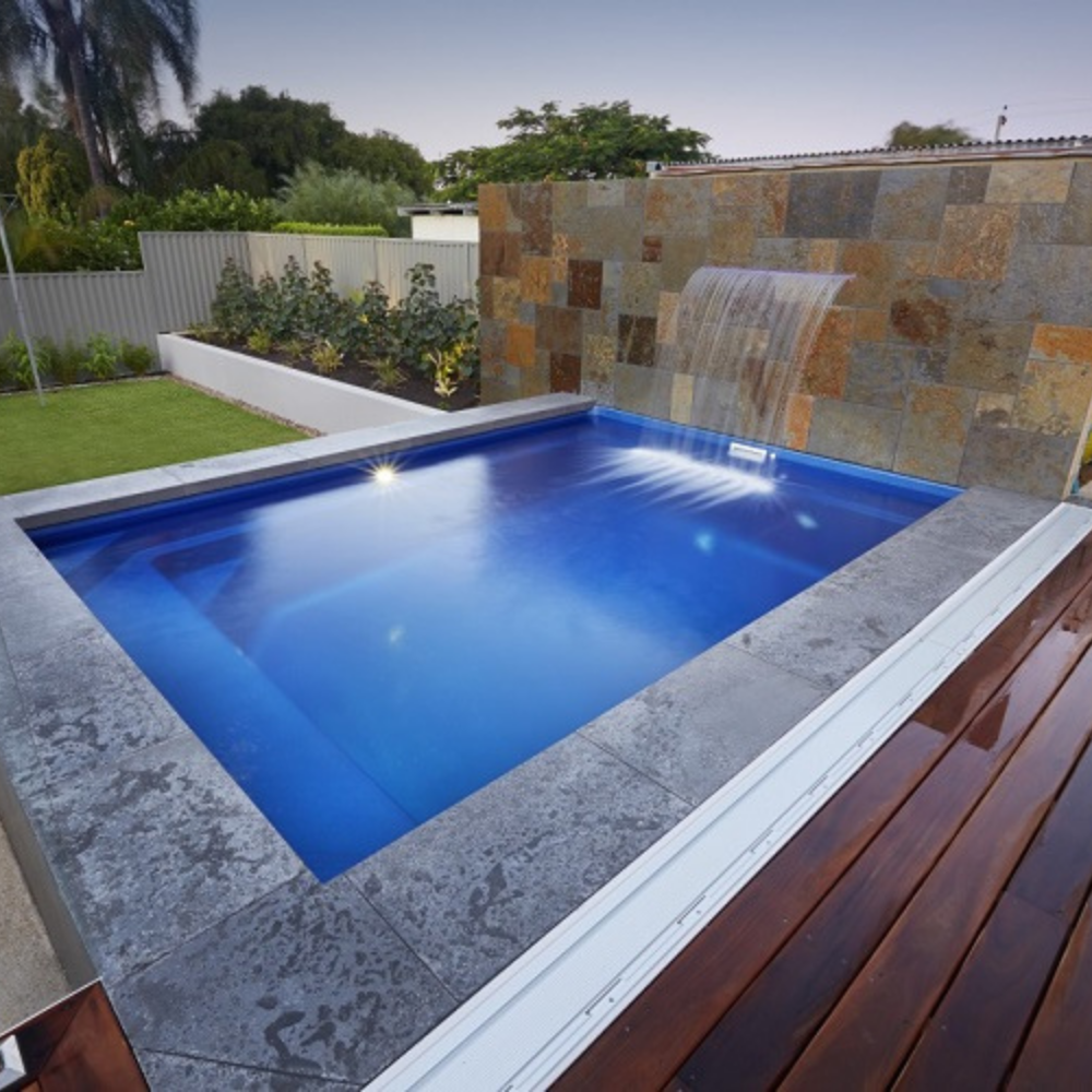 Billabong Plunge 5.5m installed with dark grey coping tiles and water feature